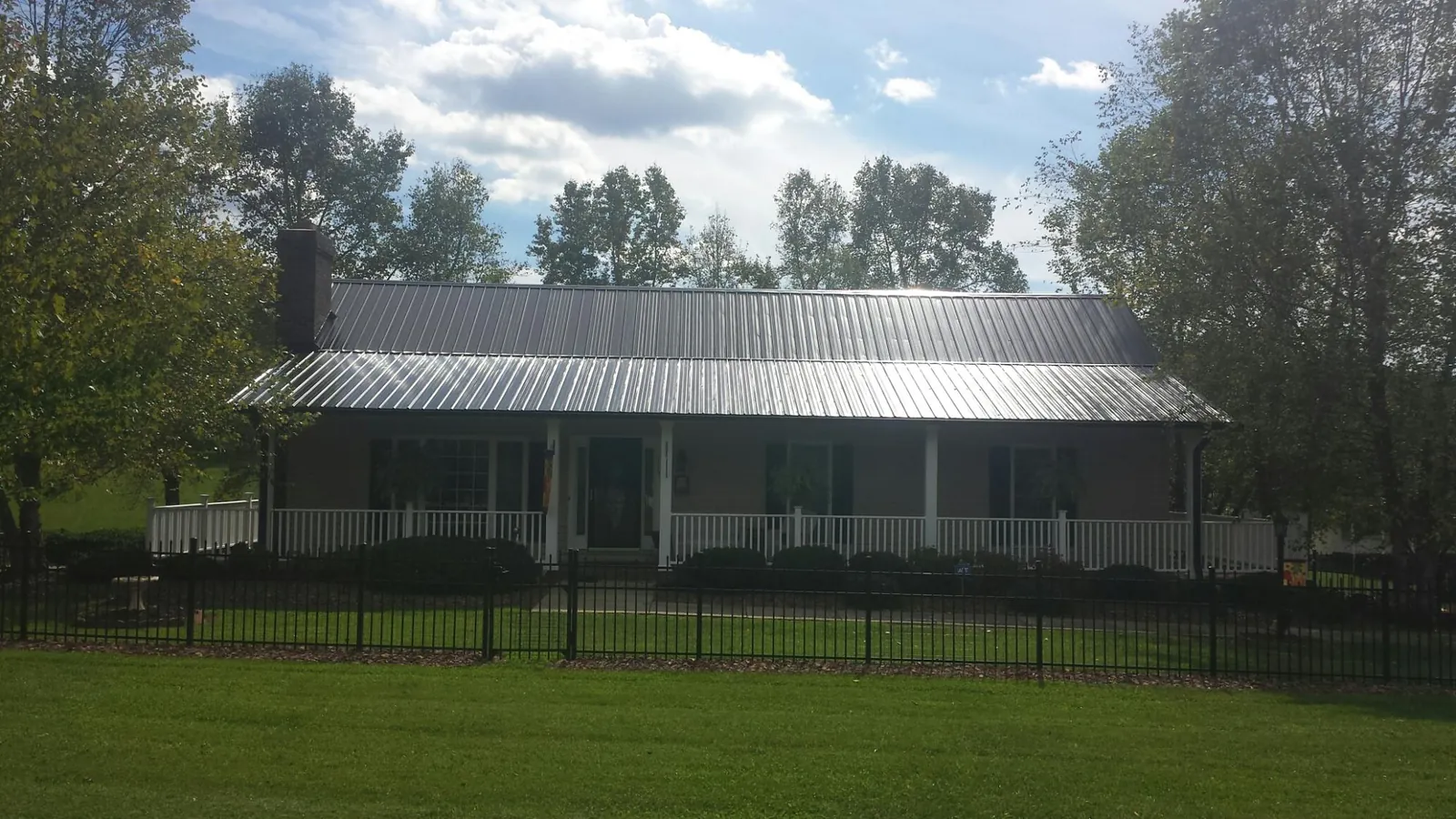 Gray metal roof on a brick ranch with a full width front porch — Gutter Guard Installation work by our crew in Autaugaville
